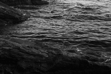 Stormy waves on a rocky seashore. Black and white sea