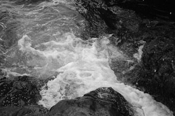 Stormy waves on a rocky seashore. Black and white sea