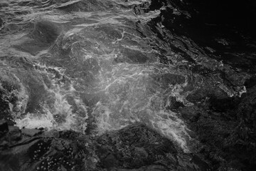 Stormy waves on a rocky seashore. Black and white sea