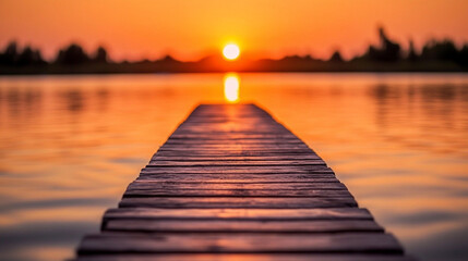 Obraz premium serene sunset casts warm hues over a wooden pier extending into a tranquil lake, symbolizing peace and reflection. The interplay of light and water evokes feelings of serenity and connection with natu