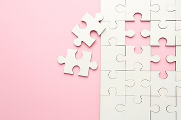 White puzzle pieces on pink background, top view