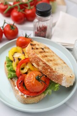 Tasty sandwich with grilled vegetables and cream cheese on white tiled table, closeup