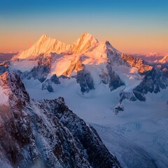Serene snow-capped peaks at sunrise with golden light touching the mountain tops