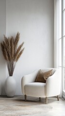 Serene minimalist living room corner featuring a plush white armchair, tall vase with pampas grass, and soft natural light from a large window.