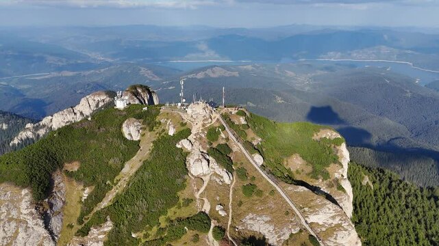 Drone capturing sunlit Toaca Peak with antennas, Bicaz Lake view