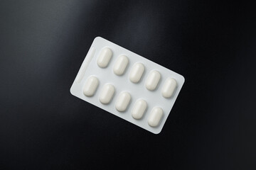 Tablet pills blister Medicine capsules on a black background