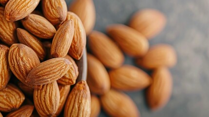 Fototapeta premium Closeup of a heap of fresh whole almonds with their characteristic golden brown skin and rich heart healthy fats and vitamin E The almonds are arranged on a rustic wooden surface