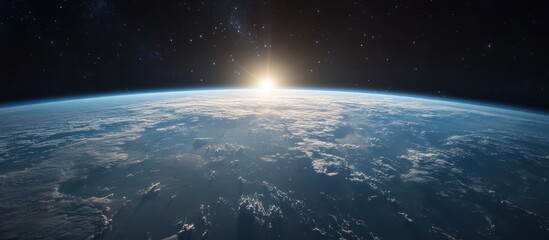 Fototapeta premium A stunning view of Earth from space, showcasing the sunrise over a cloud-covered horizon against a backdrop of twinkling stars.