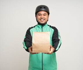 Young asian rider wearing green jacket uniform and bike helmet various action holding food paper bag delivery to customer. Male delivery service worker. Courier and shipping food service.