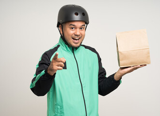 Young asian rider wearing green jacket uniform and bike helmet various action holding food paper bag delivery to customer. Male delivery service worker. Courier and shipping food service.