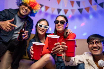 New Year's Party. Group of asian friend party in the house with disco light having fun and dancing together. Enjoy Singing karaoke listening music drinking beer celebration in new year happy hour.