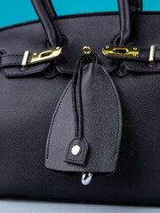 Close up of black   leather key holder with keys on fashionable black  bag