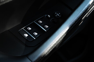 Obraz premium Interior of modern car. Side door buttons: window, mirror adjustment buttons, door lock. Car inside.