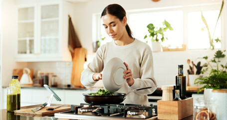 Woman, cooking and green salad in kitchen with phone for live streaming, online recipe and meal prep by stove. Nutrition influencer, food blogger or vegan chef with social media tutorial in apartment