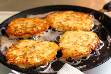 Zucchini fritters sizzle in a skillet, golden and crispy, embodying the essence of healthy comfort food. Their inviting aroma fills the air, promising a delightful culinary experience