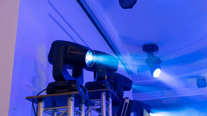 A blue light is on a stand with two other lights