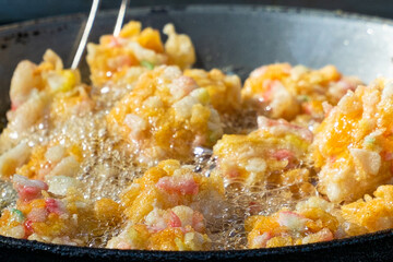 Fried food is a street food that many people like. Corn fritters are being fried