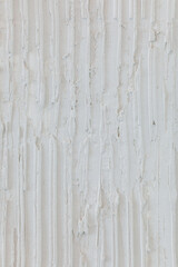 Gray background made of a textured, seamless plaster with vertical strokes. Decorative and protective purpose.