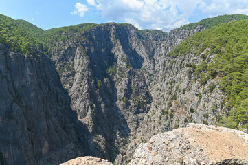 Mountain landscape with deep steep gorges covered with sparse forest