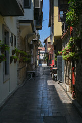 A narrow cobbled street in a resort town with flower pots along the walls