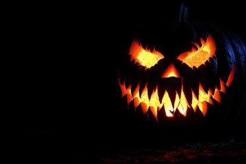Fanged jack-o'-lantern isolated in the dark.