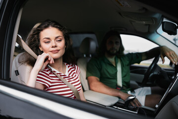 Happy couple enjoying a car ride with the woman in a striped shirt and the man in a green shirt The scene captures casual moments during travel