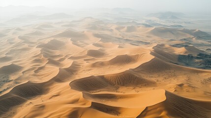 Aerial view of a vast desert landscape, with rolling sand dunes stretching as far as the eye can see.