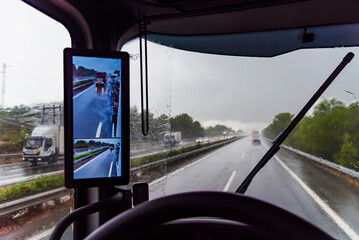 View from the driver's seat of a truck on a highway under heavy rain that prevents good visibility.