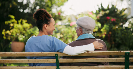 Fototapeta premium Caregiver, senior woman and relax on bench outdoor for nursing support, retirement and comic conversation. Back, volunteer and people with comfort for nature wellness, funny discussion and empathy