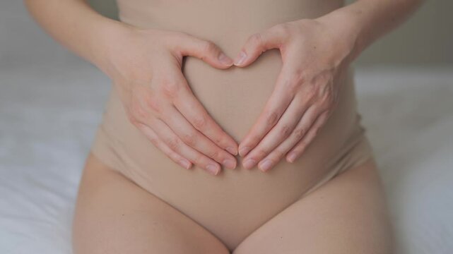 pregnant woman indoors. health pregnancy motherhood procreation. Closeup belly of a pregnant woman. woman waiting for a newborn baby. pregnant woman holding her belly. Closeup belly in beige underwear