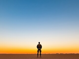 Fototapeta premium A solitary figure gazes at the horizon during sunset, reflecting on vast landscapes and the beauty of solitude.
