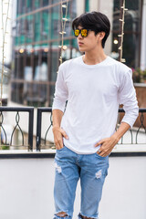 Fototapeta premium Young Asian Man in White Long Sleeve Doing Poses Outdoor