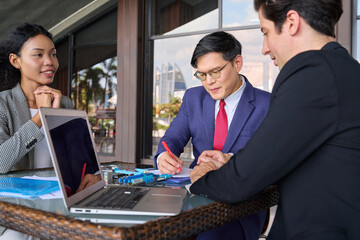 Diverse group of business people working with laptop and information papers to make a plan for new...