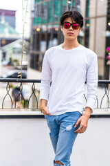 Young Asian Man in White Long Sleeve Shirt Posing in Outdoor Environment