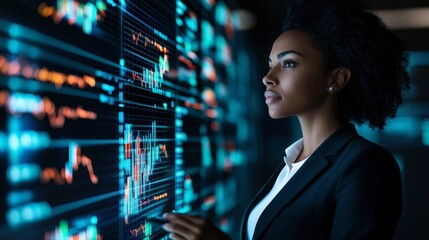 Fototapeta premium A professional woman analyzes financial data displayed on a digital interface, showcasing her focus and expertise in a technology-driven environment.
