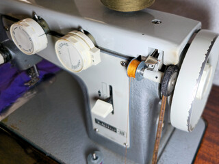 Old sewing machine. Sewing on an old sewing machine. Spool of thread on a working old sewing machine.

