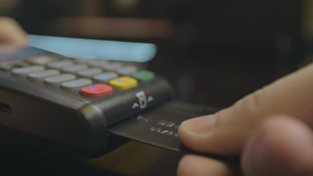 Credit card machine for money transaction. Man hand with credit card swipe through pos terminal and enter pin code. Banking services of electronic money. Financial success and safety.