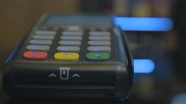 Closeup shot of customer pay over the wireless tradings card-reader. Adult human hands of businessman use bankcard: leans, entering password to withdraw funds then hold and sliding. Noncash payments.