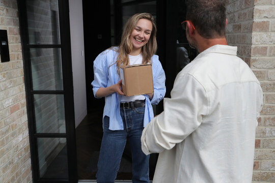 Woman receiving package from delivery man
