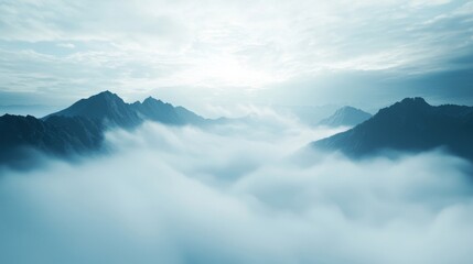 A mountain range veiled in fog, with only the highest peaks visible above the clouds, creating a mystical, otherworldly scene.