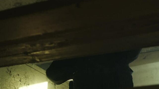 SWAT forces operator in black gear walking up a rusty old staircase in an abandoned warehouse