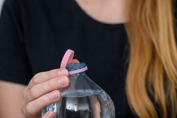 Otwarta plastikowa butelka z surowców wtórnych z różową nakrętka,  © Paweł Kacperek