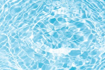 Blue water with ripples on the surface. Defocus blurred transparent blue colored clear calm water surface texture with splashes and bubbles. Water waves with shining pattern texture background.