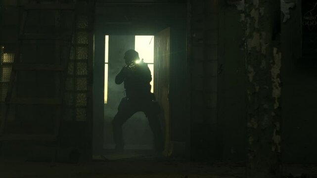 SWAT operator in all black gear and an assault rifle breaching a door in an abandoned warehouse