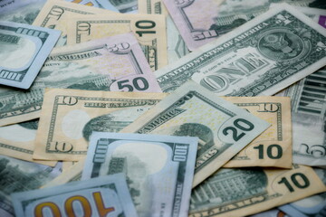 Big amount of US dollar bills in different nominations on table. Many dollar banknotes under natural light