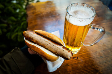 A Bratwurst sausage hot dog with cold beer