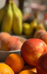 A vibrant close-up of assorted fresh fruits, featuring crisp apples and juicy oranges in the foreground, with ripe bananas softly blurred in the background, highlighting their vivid colors