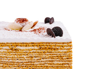 Delicious multi layered honey cake decorated with chocolate and white cream standing on white...