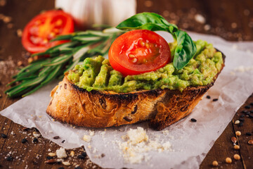 Toasted multigrain bread with avocado spread, cherry tomato and basil leaf