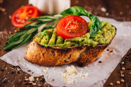 Toasted multigrain bread with avocado spread, cherry tomato and basil leaf